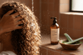 Person washing curly hair to clarify without drying; clarifying curly hair products in use.